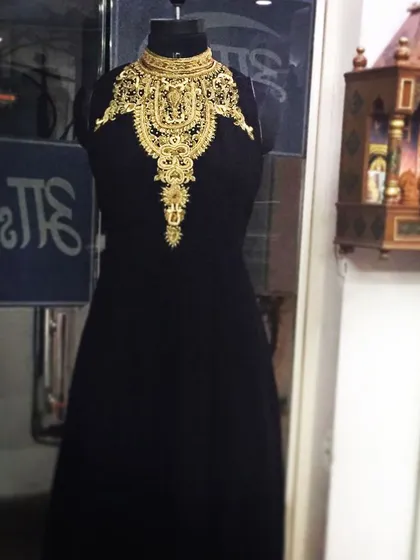 I love creating bold, statement pieces like this black evening gown. It combines a modern, high-neck silhouette with traditional, heavy gold zari and dabka embroidery, creating a stunning Indo-Western look that is sure to turn heads.