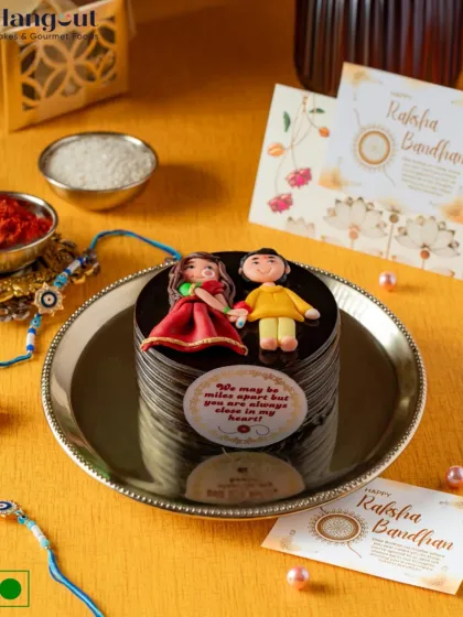 This Dutch Truffle Bento Cake for Rakhi is topped with handcrafted fondant figurines of a brother and sister. It's a heartfelt and delicious way to celebrate the timeless bond between siblings.