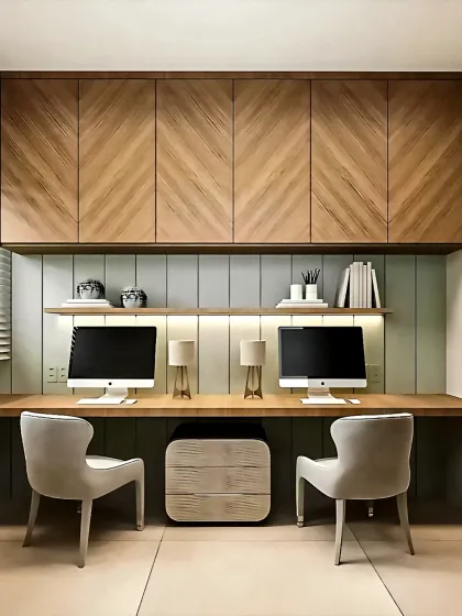 I designed this clean and symmetrical dual-desk workstation for a modern home office. The chevron-patterned wood cabinetry overhead provides ample storage, while the integrated LED lighting ensures a well-lit work surface for two.