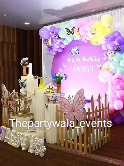 A side view of the pastel butterfly theme, showing how the balloon arch frames the custom backdrop. The little details like the mini Ferris wheel add a touch of whimsy.