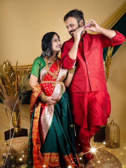 A playful and traditional couple's portrait. The partner playfully uses a flute while his partner looks on, both dressed in beautiful Indian attire.