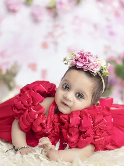 A princess in red, lying on a soft rug surrounded by a beautiful floral background. The colors are so rich and vibrant.