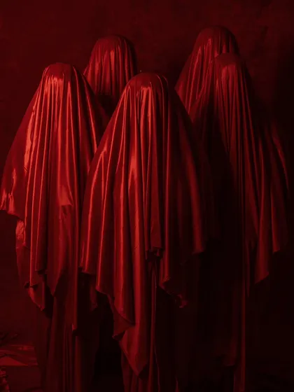 The opening shot of a conceptual jewelry campaign, creating mystery with figures shrouded in red satin. It sets a dramatic and intriguing tone for the series.