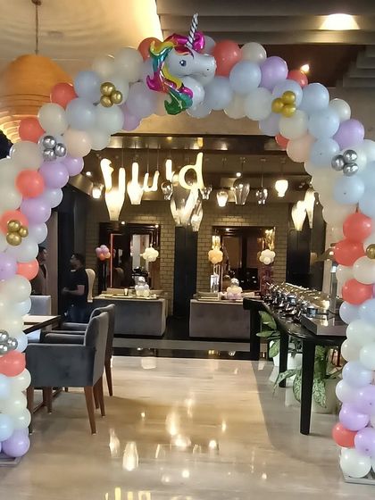A unicorn-themed balloon arch at the entrance of the party venue.