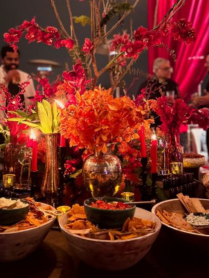 The ambiance of an evening celebration, where warm lighting and rich floral arrangements complement our bountiful displays of fresh dips and artisanal breads. Every element is designed to create a cohesive and luxurious experience.