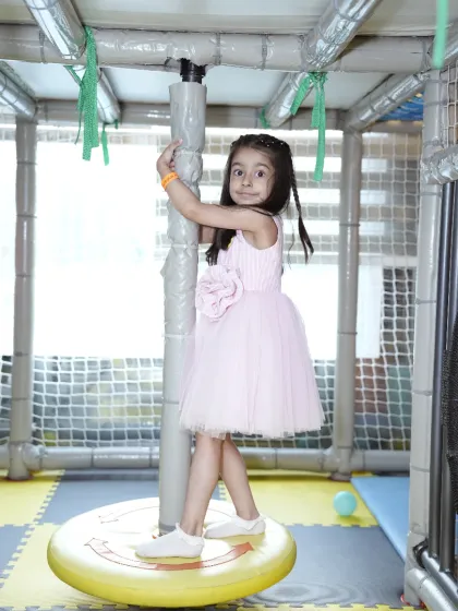 A young girl enjoys a spin on one of our merry-go-round features inside the soft play area, designed for safe and imaginative fun.