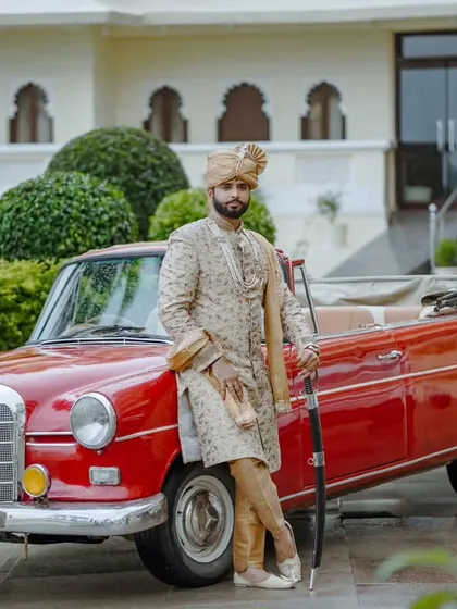 The groom deserves his own hero moment. Here, a groom in his royal sherwani poses with a vintage car, creating a portrait that is stylish, confident, and has a touch of classic Bollywood charm. It's about capturing his personality on the big day.