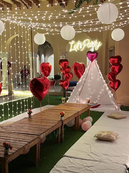 Another perspective of the garden party cabana, highlighting the combination of fairy lights and paper lanterns. The low wooden table and floor seating are ready for guests to enjoy a unique dining experience.