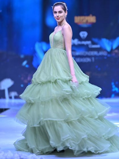 Another angle of the sage green tiered gown, showing how the layers of tulle create a soft, flowing silhouette inspired by nature.