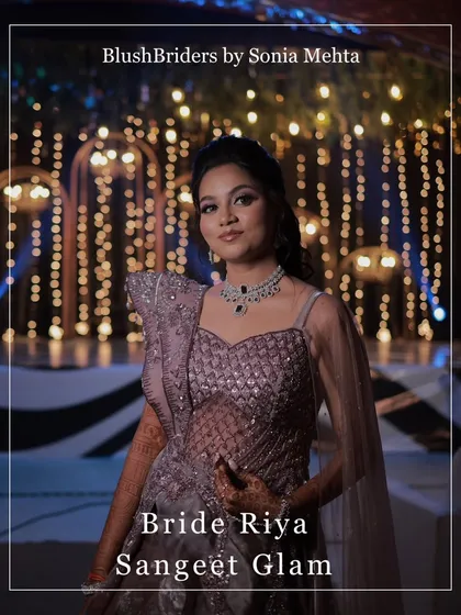 A portrait of the bride showcasing her full sangeet glam look, from the bold eye makeup to the statement diamond necklace.