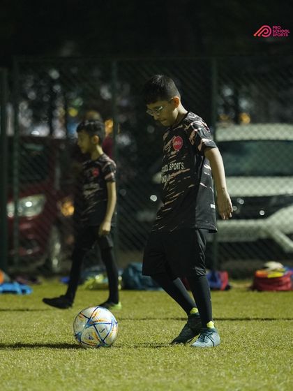 A player focuses on their first touch, a fundamental skill we emphasize in our coaching.