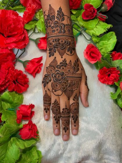 Another view of this floral party henna, framed by beautiful red flowers.