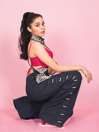 A creative pose from Eisha Singh's studio session. This shot highlights the unique styling and her ability to work with unconventional fashion pieces.