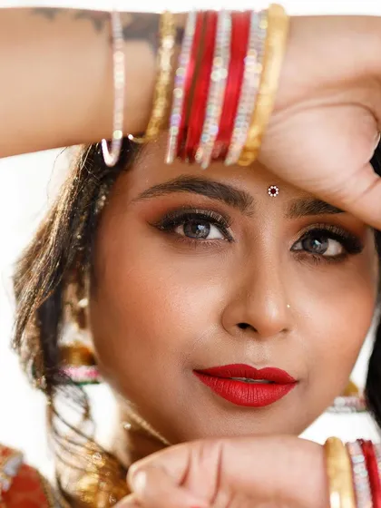 A close-up view of a classic bridal photoshoot look. You can see the detail in the golden-bronze eyeshadow, the sharp winged eyeliner, and the vibrant red lip. My focus is always on creating a smooth, skin-like finish that looks perfect both in person and on camera.