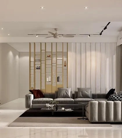 We designed this living room with a striking black marble feature wall for the media unit, creating a bold visual anchor. The space is balanced with a plush grey sectional sofa, fluted wall paneling, and a metallic partition for subtle separation.
