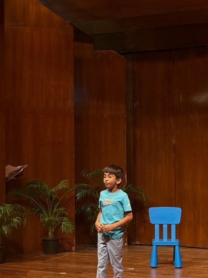 A student practices his monologue on the empty stage, a quiet moment of focus and preparation.