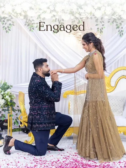 The perfect "I said yes" moment. We create beautiful backdrops like this one with white florals and drapery, ensuring your engagement photos are as magical as the moment itself.