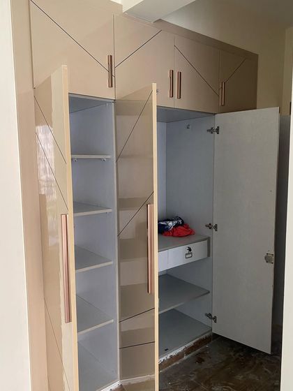 The interior view of the four-shutter wardrobe, revealing a mix of open shelves and hanging sections for versatile storage.