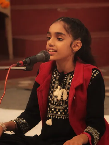 A young student performing with great confidence and joy at the 'Swarveni Aradhana'.