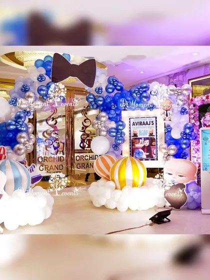 The full entrance setup for the Boss Baby party, featuring a large balloon arch with a bowtie accent, character cutouts, and a digital welcome kiosk.