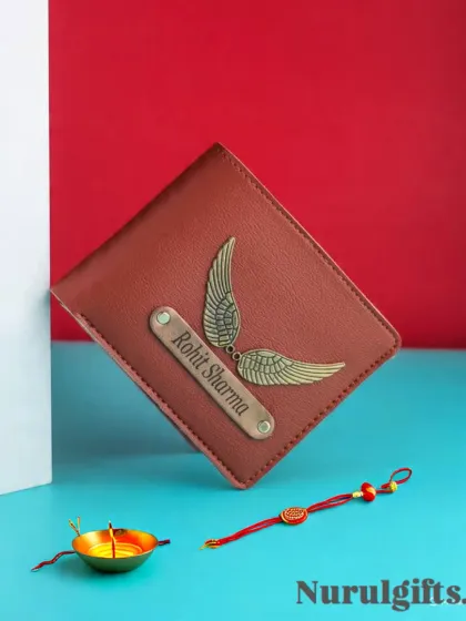 A beautiful Rakhi gift featuring a personalized wallet with a name and wings charm, shown with a traditional Rakhi and a diya.