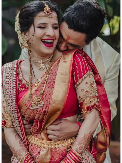 Capturing a moment of pure happiness. Our bride radiates joy in her custom-designed red silk saree and intricately embroidered blouse. It is my greatest honor to dress couples for the most cherished moments of their lives.