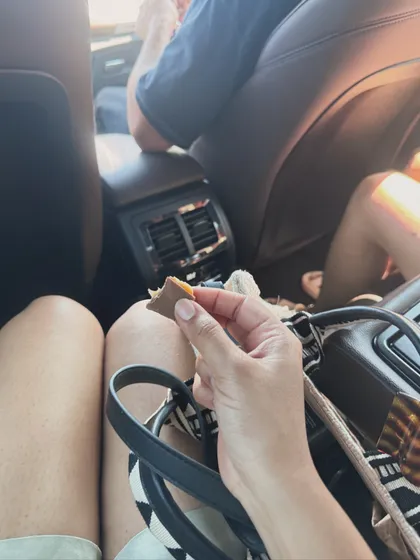 A "slice of life" shot from inside a car, showing a snack during a road trip.
