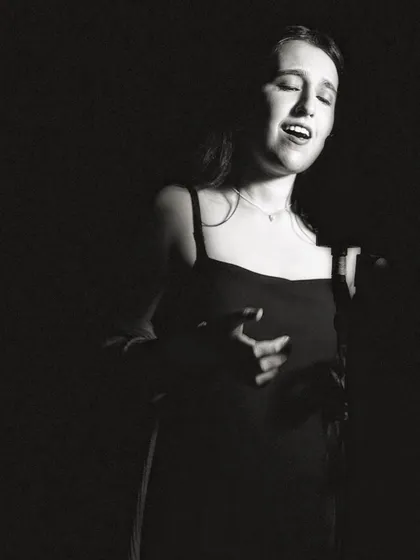 A classic singer's pose in black and white. This photo captures the essence of a vocalist lost in their song.