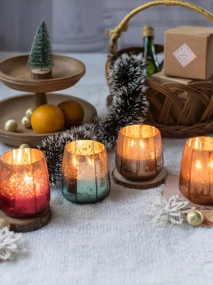 Our winter-scented candles in festive mercury glass jars. This collection features four distinct holiday fragrances, from Apple Cinnamon to Bahama Breeze, each designed to capture the spirit of the season.