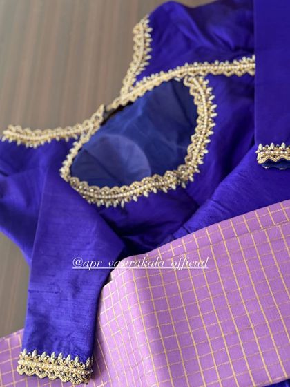 A royal blue blouse with a sheer panel on the back, framed with delicate embroidery.