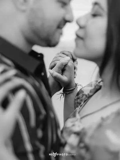 A black and white close-up focusing on the couple's hands and their gentle embrace. This shot highlights the small, intimate details.
