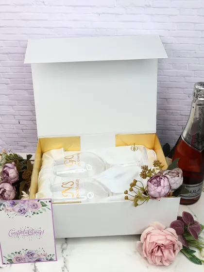 The complete view of our personalized wine glass gift set, presented in a white gift box with a custom congratulations card.