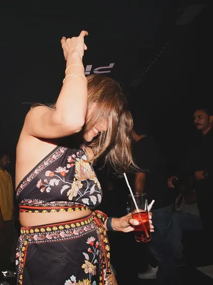 A guest dancing with a drink in hand, enjoying the unique blend of sounds.