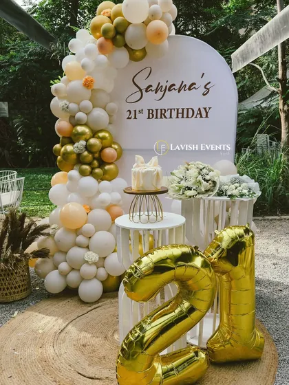 A full view of the elegant 21st birthday setup, complete with large foil number balloons.