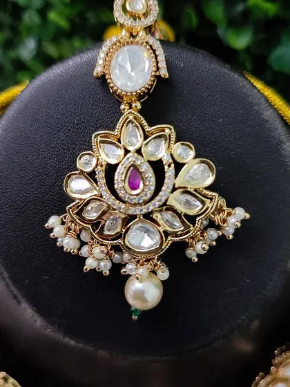 The maang tikka from this set, perfectly designed to match the pendant of the necklace.