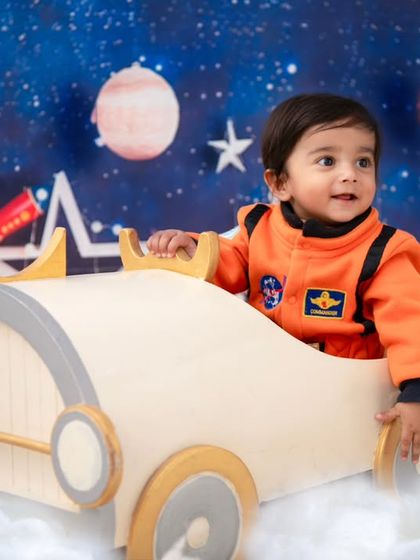 Ready for takeoff! This little explorer is at the helm of his spaceship, ready for an adventure among the planets and stars.