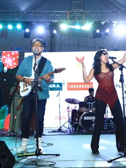 Another powerful shot of me performing on stage with the band. The bright lights and large screen in the background highlight the professional production of our shows.