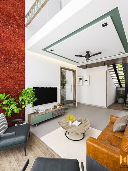 The living room of the Calicut duplex, featuring a double-height red textured wall, a mix of leather and fabric seating, and a view of the indoor courtyard.