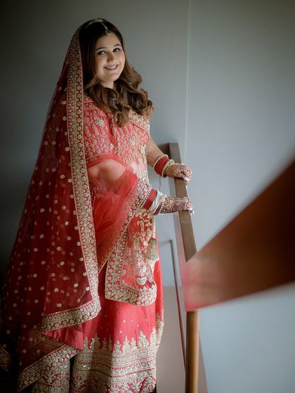 A beautiful portrait on the stairs. The soft lighting highlights the glowing finish of her skin and the intricate embroidery of her outfit.