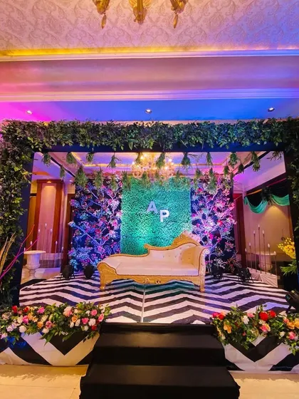This engagement stage combines nature with modern design. I built a lush green wall as the backdrop, personalized with the couple's initials, and framed it with a foliage-covered canopy and a striking black-and-white patterned floor.
