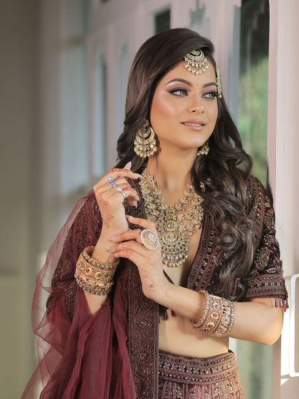A beautiful shot of a bride in a traditional gold-toned jewellery set, complete with heavy bangles and a statement ring. A perfect blend of grace and heritage.