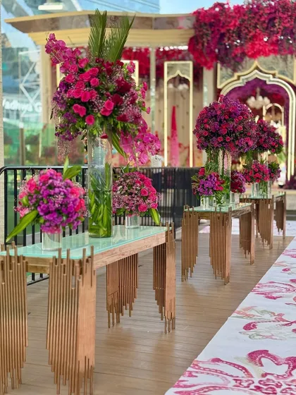 More views of the contemporary console tables adorned with large, vibrant floral arrangements, set against the backdrop of the city skyline.