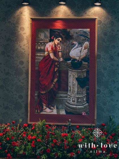 A beautiful painting of Damayanti and the swan, surrounded by a bed of red roses. This combination of art and florals creates a powerful and romantic focal point.