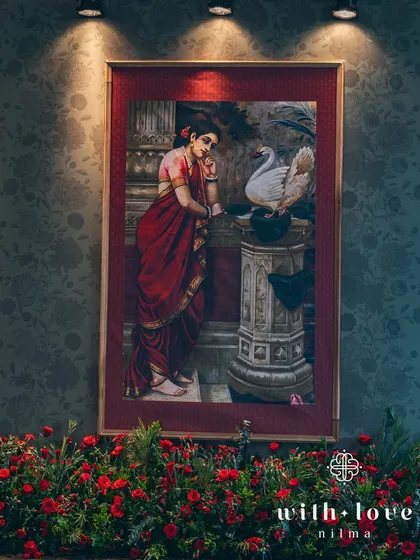 A beautiful painting of Damayanti and the swan, surrounded by a bed of red roses. This combination of art and florals creates a powerful and romantic focal point.