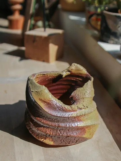 Another view of the textured wood-fired vessel, showing the deep grooves and unique coloration. Each piece from the wood kiln is a surprise, a gift from the fire.