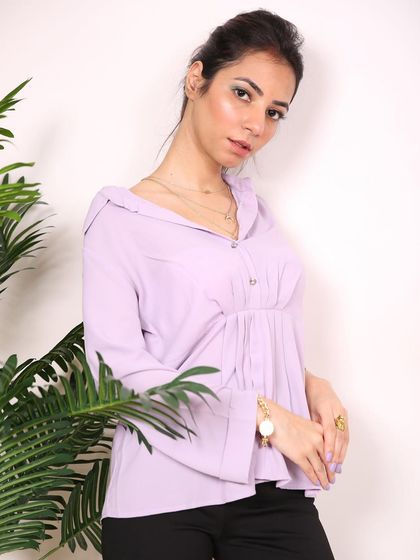 A studio shot for a fashion blogger, using plants as a foreground element to add depth and a touch of nature.