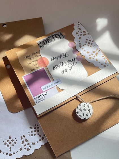 The outside of the birthday card, decorated with vintage paper, a doily, and a custom tag. It’s paired with a mini crochet bouquet to make the gift complete.