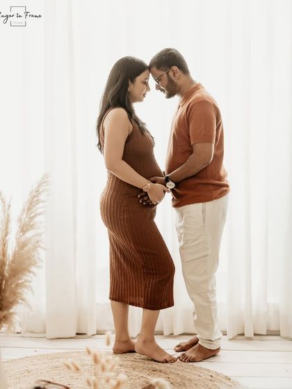 A full-length silhouette shot of an expecting couple against a bright window. This artistic photo beautifully outlines the mom-to-be's form and their connection.