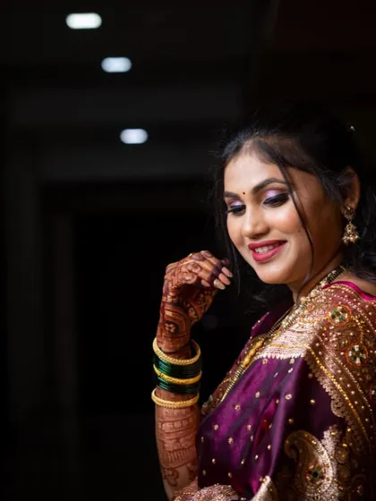 A candid shot of Gauri during her celebrations. The purple saree and shimmery eye makeup create a beautiful, dreamy effect in this low-light photo.
