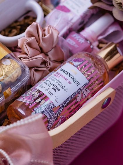 A close-up of the 'Dreaming of Paris' shower gel and other pink-themed items in the best friend hamper, showing a cohesive color story.